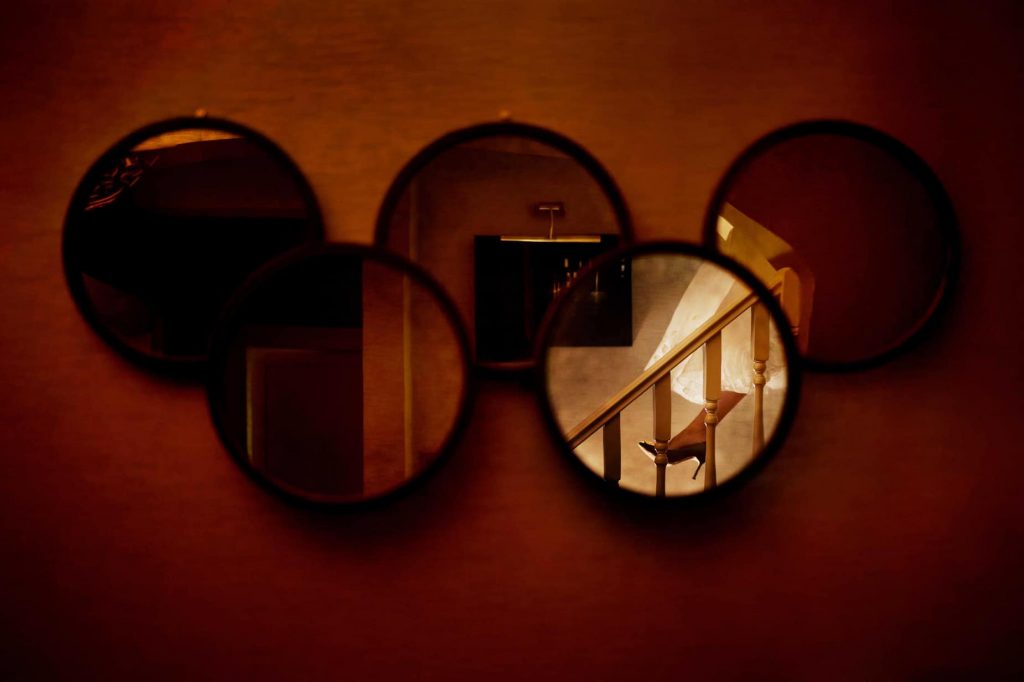 Circular mirror on the wall with a reflection of the bridal shoes.
