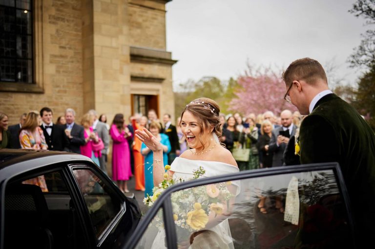 Bridal Couple getting into the car at the venue
