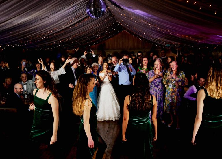 Couple and guests dancing in a marquee at reception