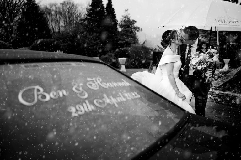 Black and white image of couple, car in front with their names and wedding dates