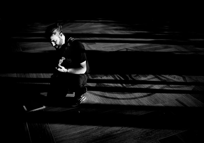 black and white photograph of a guitar player from a high angle with natural light beams for the discussion on how to pick a wedding band