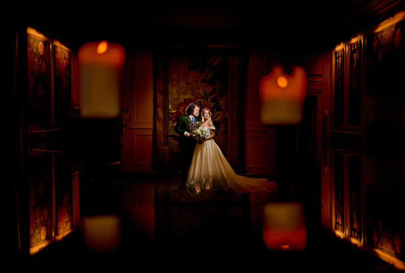Bridal couple in their venue candles framing them in the foreground for the best of 2025 weddings